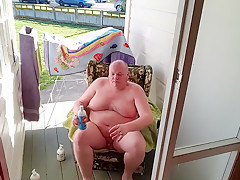 Fat man masturbates by a public road.